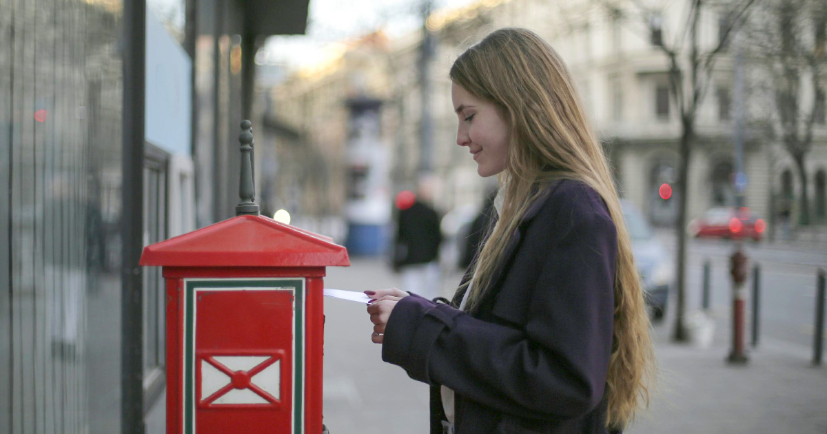 woman mailing a support letter to fundraise for a missions trip