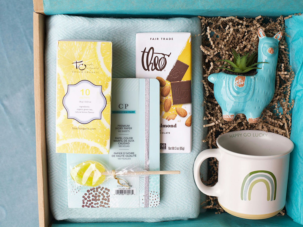 box filled with chocolate bars trinkets and mug for missionary care package