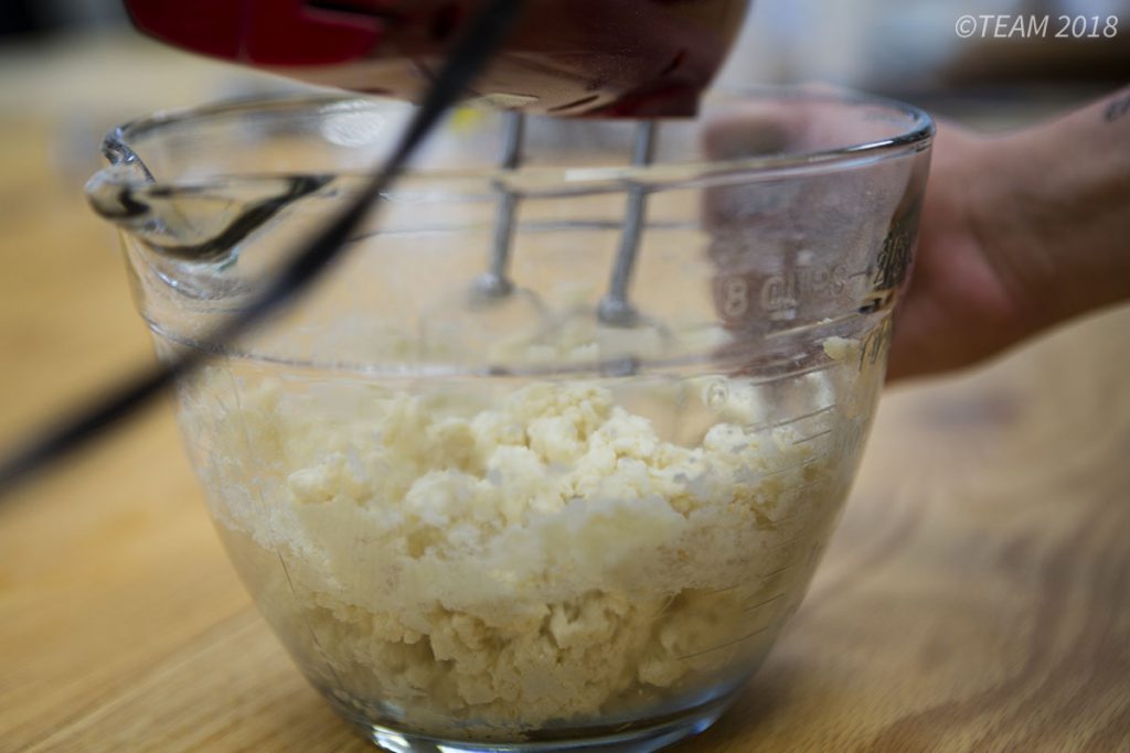 One of the first steps in making Apple Torte is mixing butter and sugar together in a bowl.