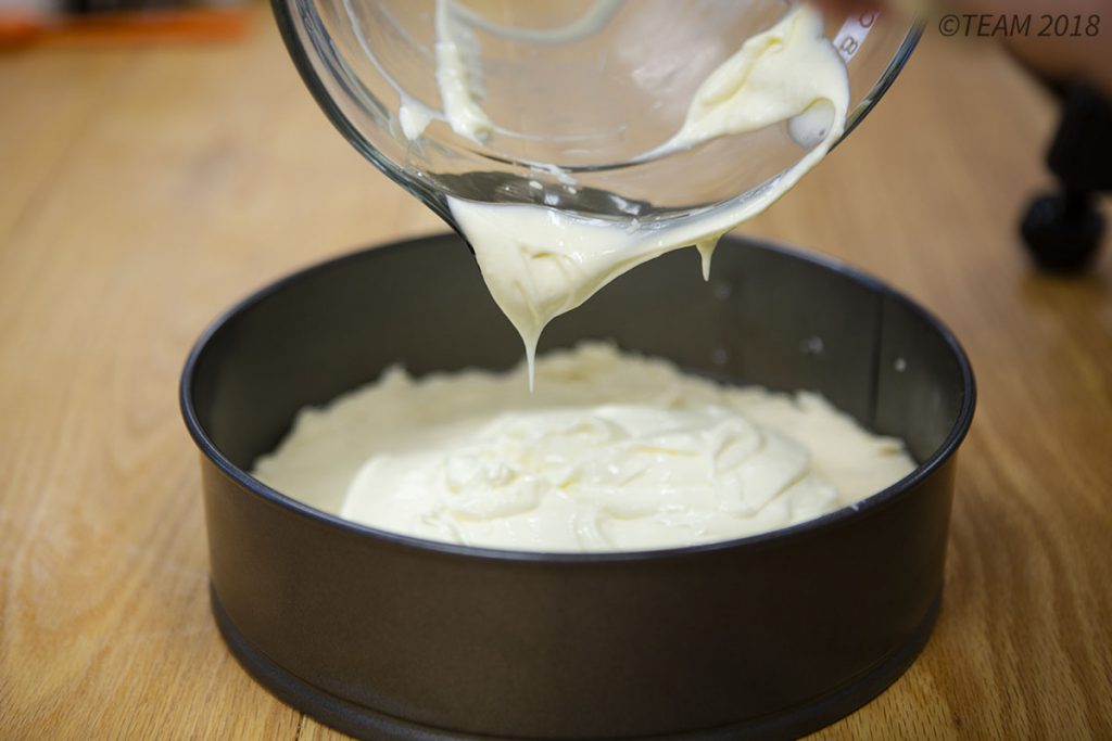 The filling of the torte is poured on top of the crust.