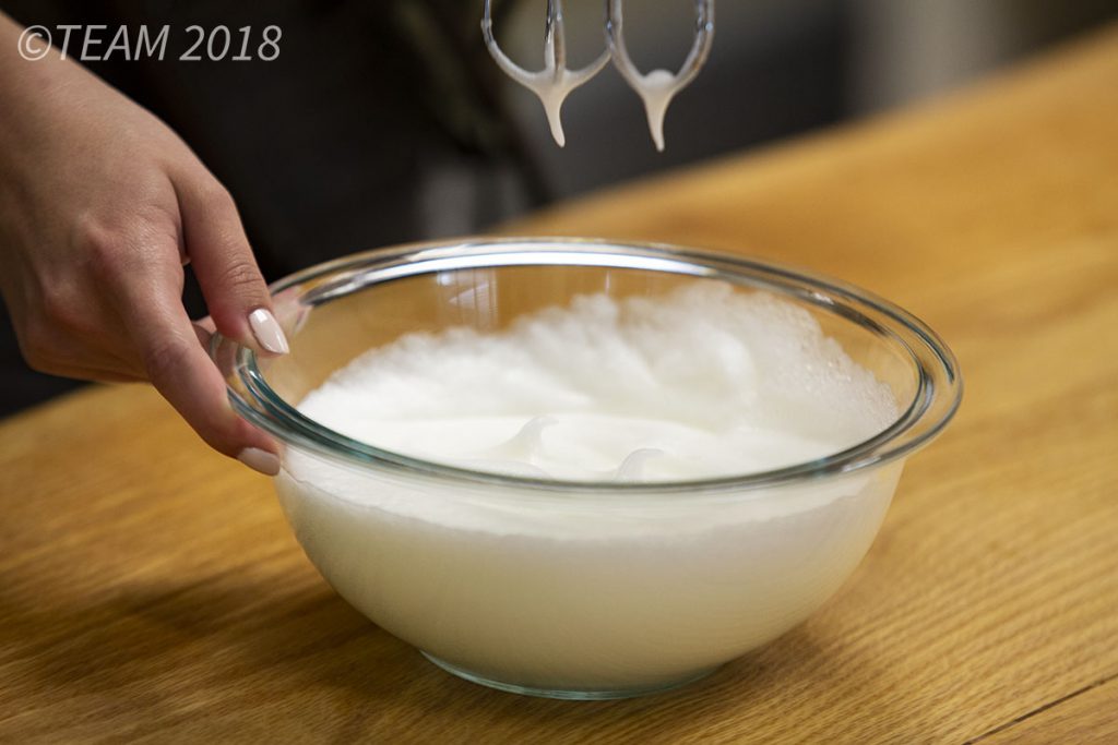 After being beaten with the mixer, the egg whites should form stiff peaks.
