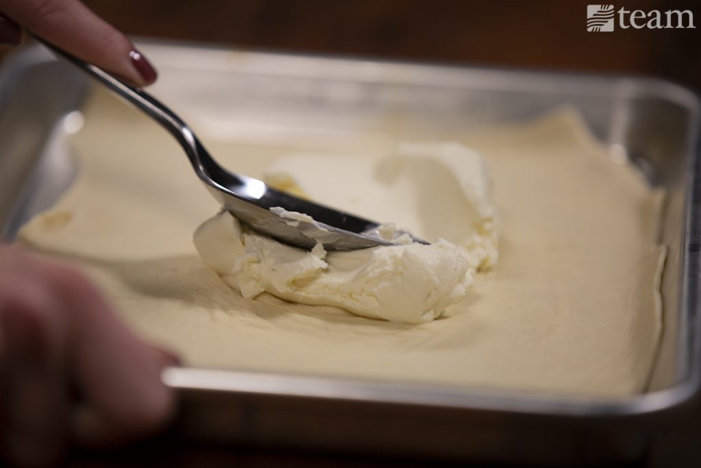 Cheese is spread across the flammkuchen