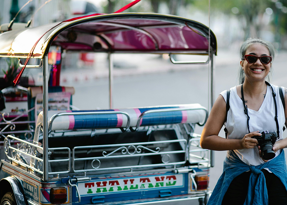 Thailand visitor next to a tuk tuk.
