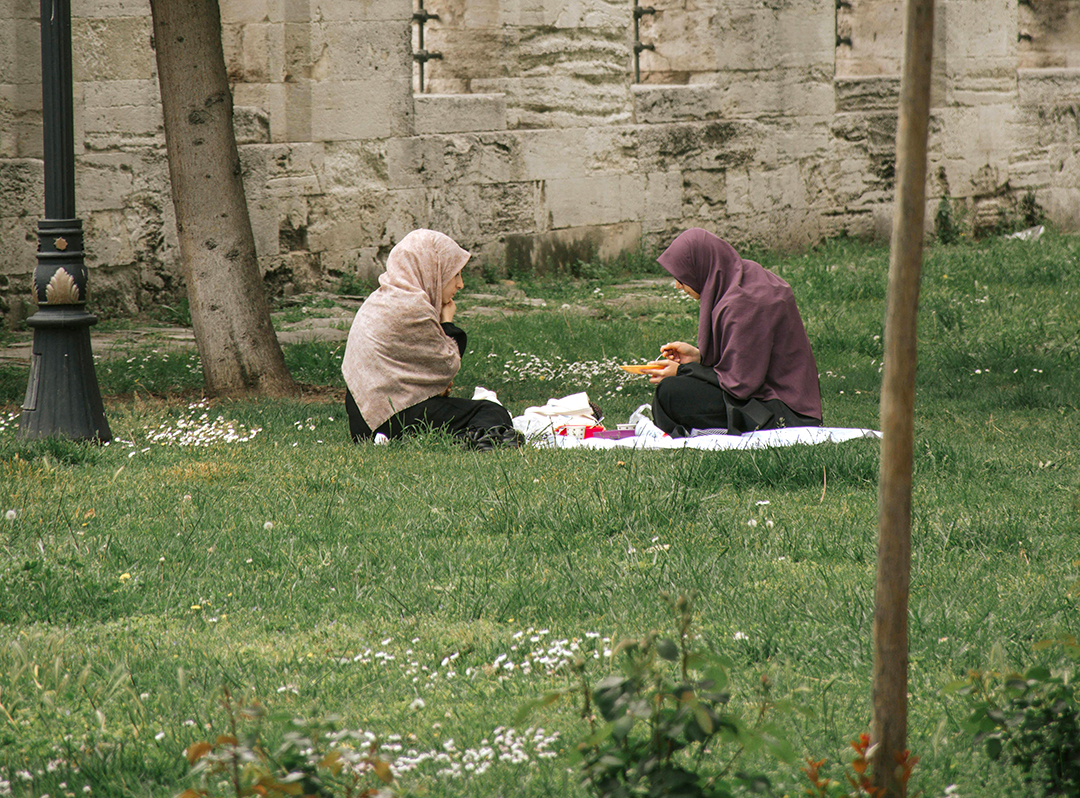 Two Muslim women sitting at a picnic.