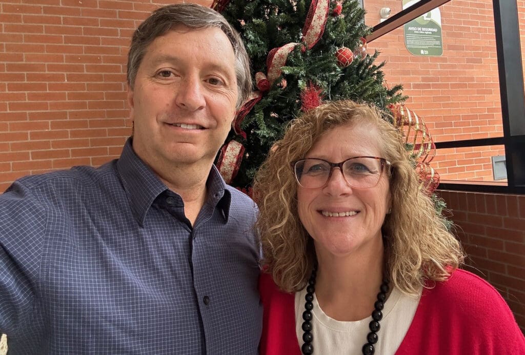 Craig and sue missionaries in Latin America smiling in front of Christmas tree