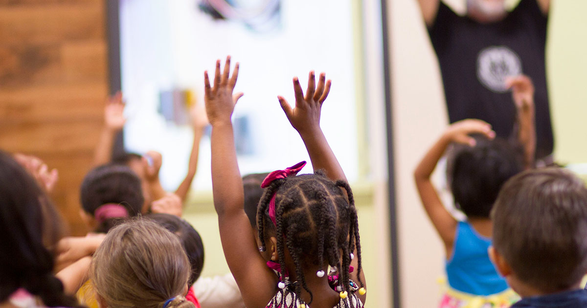little girl raising her hands in worship