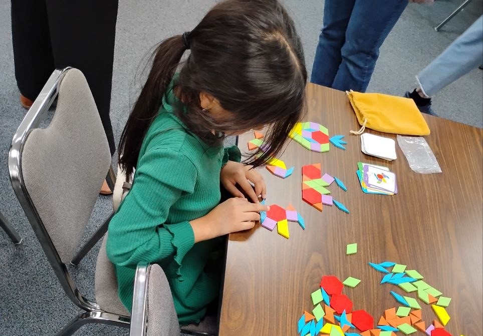 child doing a puzzle in the classroom where Roya is serving Central Asian refugees