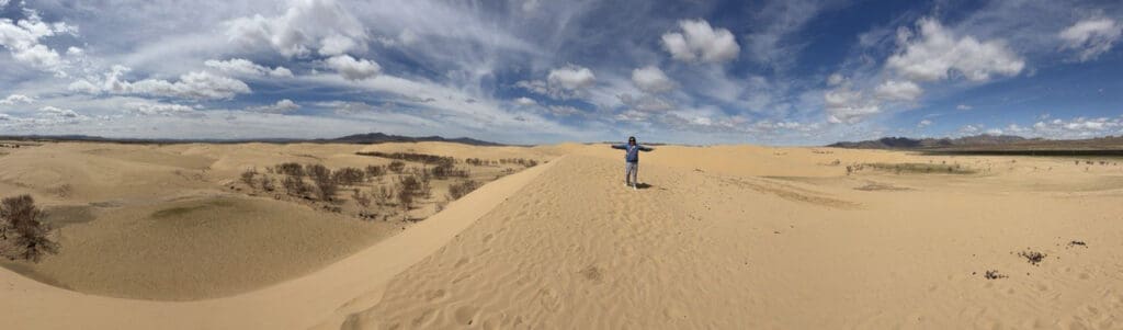 young woman on missions in Mongolia standing in the middle of a sandy desert