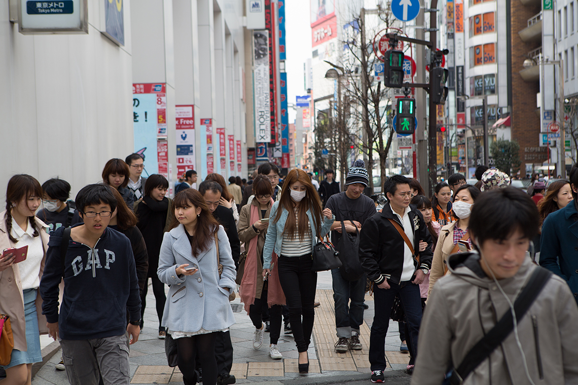 crowd of people walking down the street in Japan