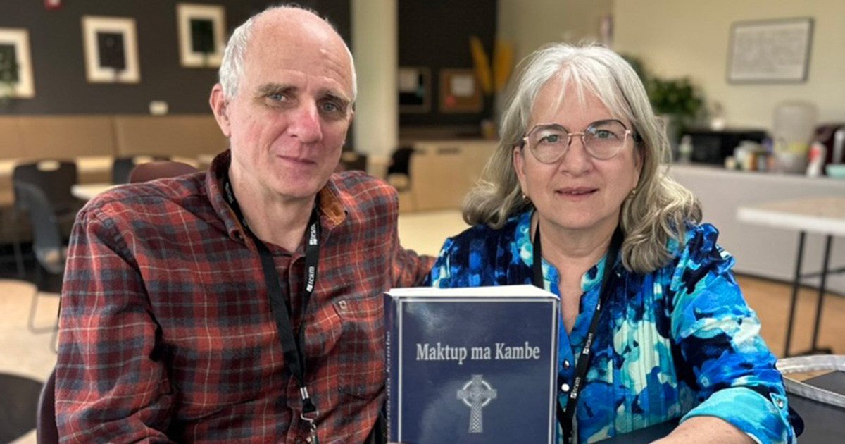 mark and Diane holding a bible from their bible translation ministry in chad