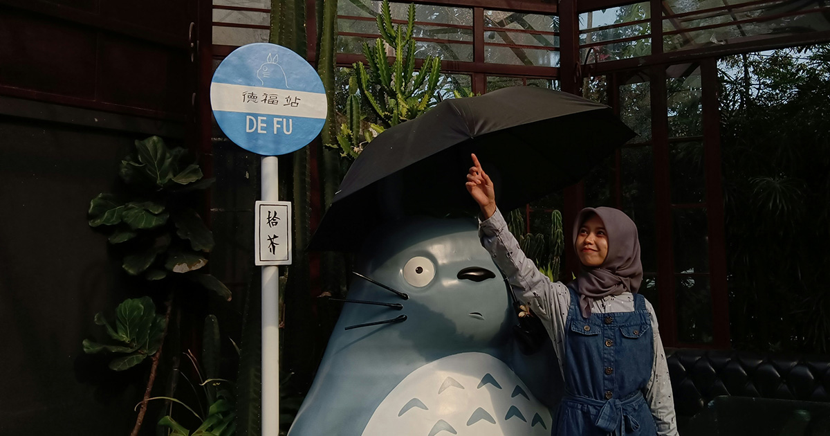 woman next to statue of mythical creature holding an umbrella